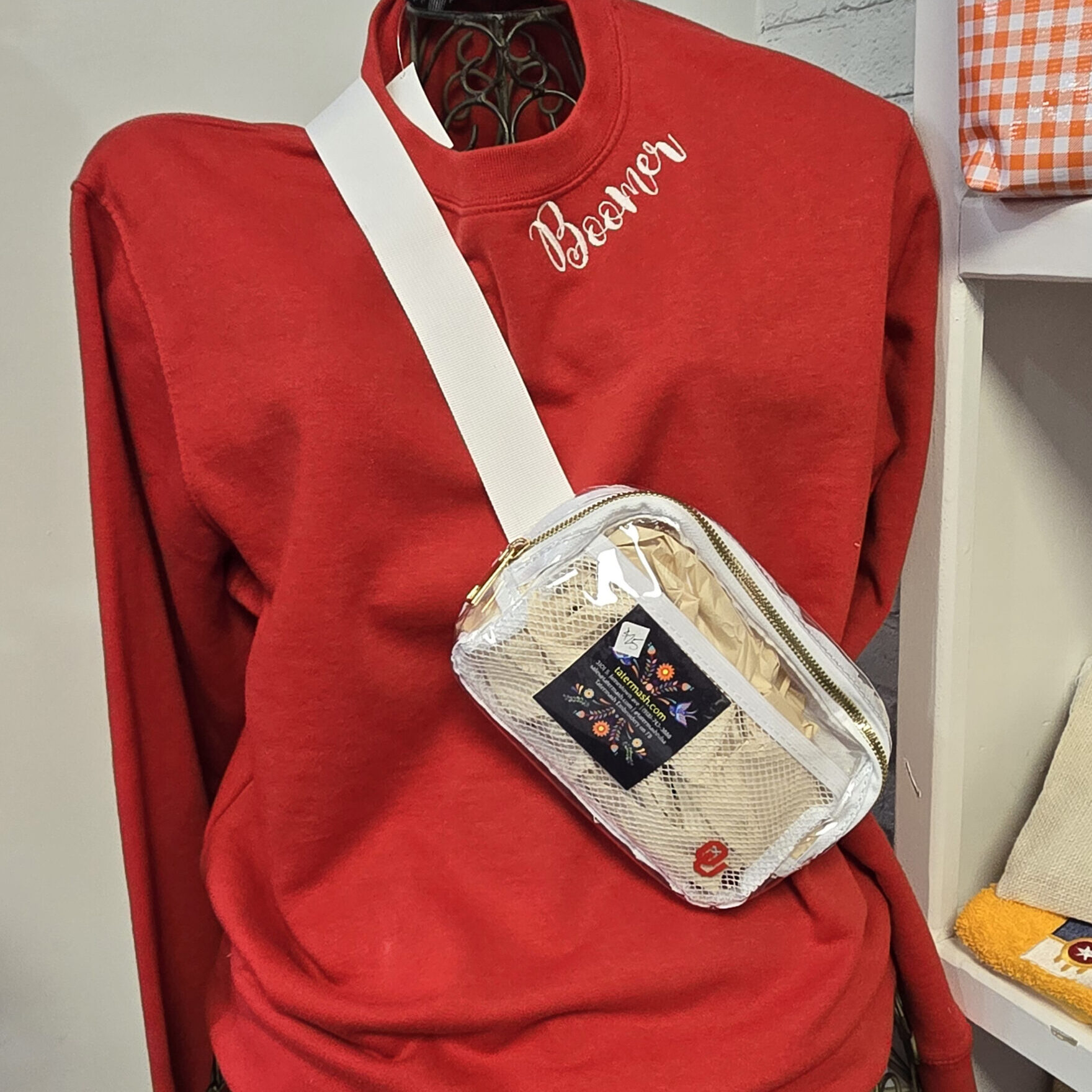 an red sweater with "boomer" on the neckline with a clear white bag with OU embroidered on it